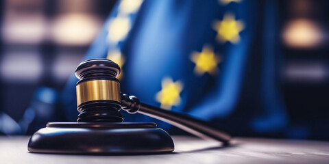 The European Union flag waving in the background, with a close-up of a wooden gavel, evoking the themes of legal authority, justice, and the power of law within the EU.