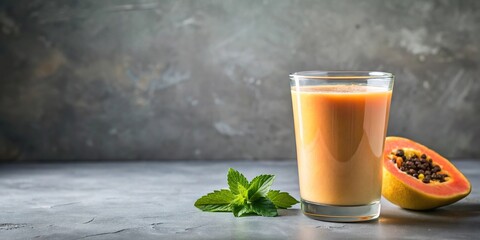 Fototapeta premium Delicious papaya milk smoothie in glass cup on gray table background