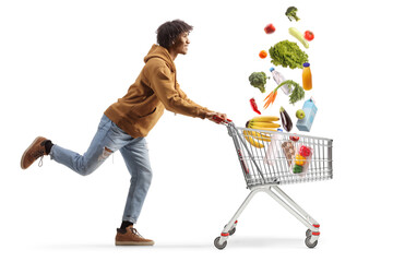 Full length profile shot of a young african american man running with a shopping cart and falling...