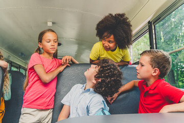 Group of young students attending primary school on a yellow school bus