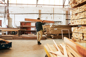 Timber, workshop and carpenter carrying wood for builder maintenance or repair project at industrial industry. Man, production and lumber for manufacturing business and woodworking trade with stack