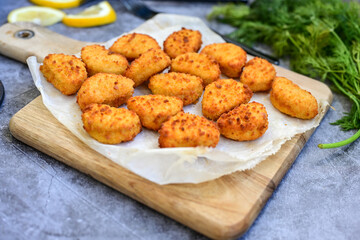 Crispy  deep fried   chicken  popcorn  nuggets and french fries . Breaded  with Cornflakes chicken  Breast fillets  with chilly peppers and fresh   basil on wooden rustic background