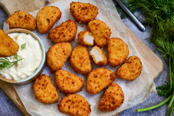 Crispy  deep fried   chicken  popcorn  nuggets and french fries . Breaded  with Cornflakes chicken  Breast fillets  with chilly peppers and fresh   basil on wooden rustic background