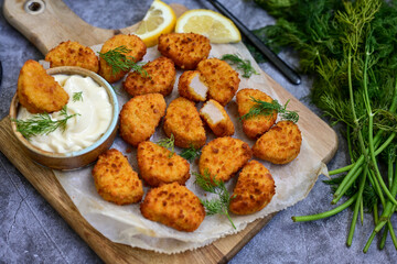 Crispy  deep fried   chicken  popcorn  nuggets and french fries . Breaded  with Cornflakes chicken  Breast fillets  with chilly peppers and fresh   basil on wooden rustic background