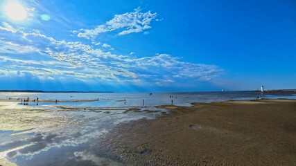 Obraz premium A vast sandy sea beach. Sunset over the sea. Beautiful sunny weather over the sea on a summer afternoon.