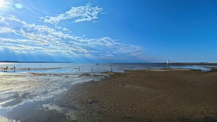 A vast sandy sea beach. Sunset over the sea. Beautiful sunny weather over the sea on a summer afternoon.