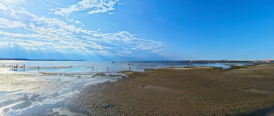 A vast sandy sea beach. Sunset over the sea. Beautiful sunny weather over the sea on a summer afternoon.