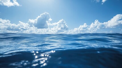 Deep blue sea surface with soft waves, reflecting the light of a bright sky, giving a peaceful vibe.