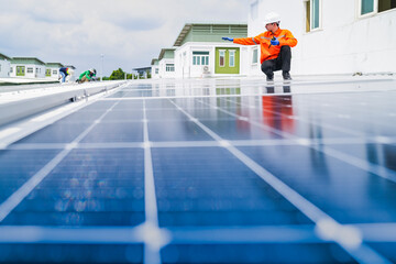 A worker in an orange safety jacket inspects solar panels on a rooftop, using a laptop to ensure proper maintenance. The scene highlights renewable energy, solar technology, and sustainable practices.