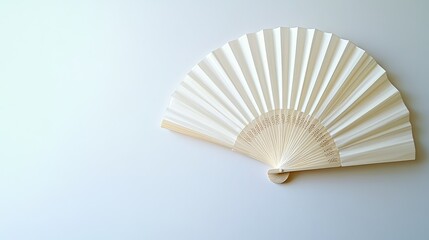 Flat lay of a traditional white folding hand fan, fully opened against a clean white background.