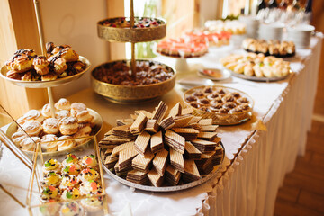Sweets on a banquet table at a corporate party. Chocolate wafers and a dessert buffet with sweet treats. Cozy restaurant offering a variety of sweet snacks for guests.