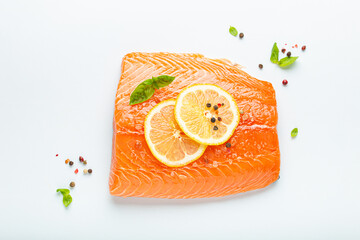 Fresh raw salmon marbled fillet isolated on white background with lemon, coarse salt, green herbs...