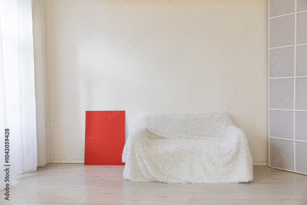 Poster White sofa in the interior of a white room with a window