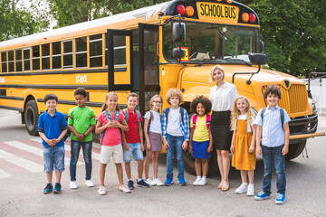 Group of young students attending primary school on a yellow school bus