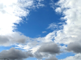 Fluffy White Clouds in a Blue Sky as A Skyscape Background