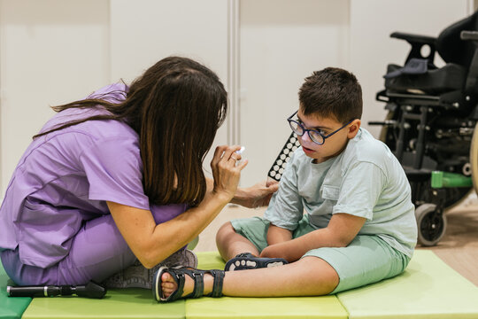 Female optometrist performing eye examination on child with cerebral palsy in medical office