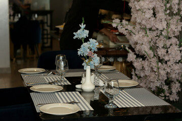Table in the restaurant in the open air with glasses of wine and serving.
