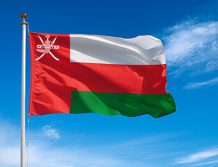 Oman flag waving in the wind against a blue sky background