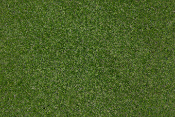 Artificial grass, covering. Artificial green grass mat, top view. Texture. Background. Artificial turf, surface made of synthetic fibers. Flat green grass texture background. Short grass
