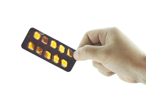 Female hand holding tablets that have been taken isolated on transparent background.