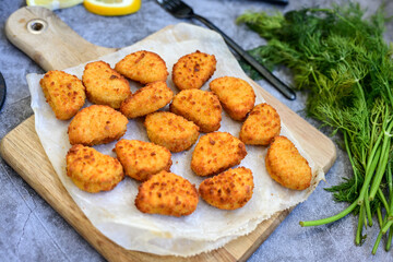 Crispy  deep fried   chicken  popcorn  nuggets and french fries . Breaded  with Cornflakes chicken  Breast fillets  with chilly peppers and fresh   basil on wooden rustic background