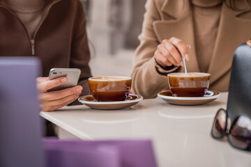 Female friends two women walking down the road and smiling at the city street. Female friendship concept. Two sisters gossiping together on the move.