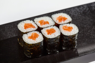 Vibrant Salmon Hosomaki Sushi Rolls Presented on Dark Slate Plate - Minimalist Food Photography