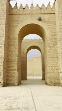 Walking through archs in Babylon great walls restored by Saddam Houssein. Babylon, Iraq. Vertical