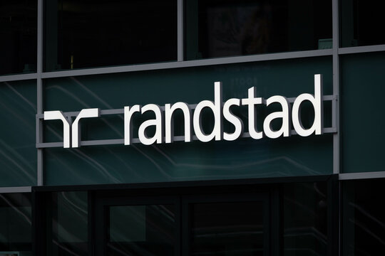 Randstad Uitzendbureau Sign on reflecting windows above the entrance. Utrecht, the Netherlands. 2 December 2023. 
