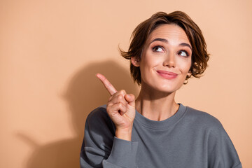 Photo portrait of attractive young woman point look empty space dressed stylish gray clothes...