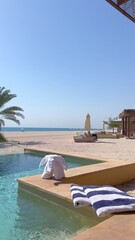 Indulge in luxury hotels resort swimming pool with plus towels and serene sunbathing areas. Nestled by beach and sea, this tourist resort highlights lifestyle of wellbeing and relaxation.