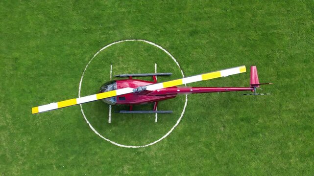 helicopter parked green grass helipad scene vibrant landscape enhances aviation upward birdseye aerial shot view top down drone heliport london scenic travel 
