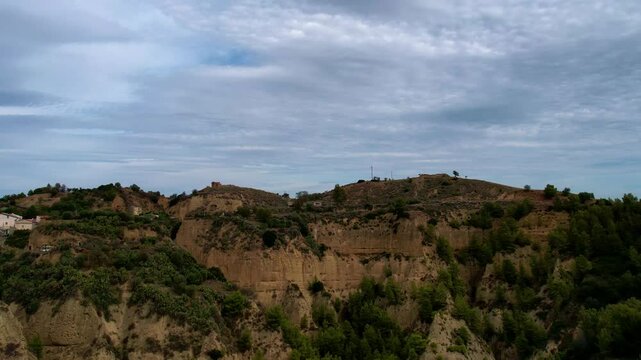4K Aerial drone video of ancient town elevated in the hills with unreal cloud shapes with a mystical look. Abandoned ghost town Tursi in Italy outback with empty houses and streets