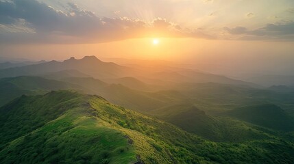 Obraz premium A breathtaking sunrise illuminating the Girnar Hills, casting a golden glow over the rugged terrain and lush greenery.