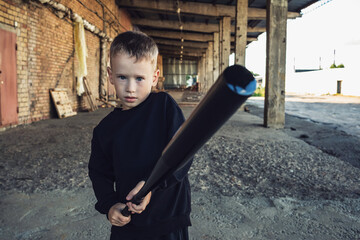 Little boy in black with a baseball bat.
