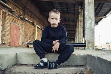 Little boy in black with a baseball bat.