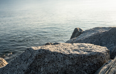 Rock Sea stones with texture surface with blurry blue ocean, cloud sky background,Aerial view Edge Cliff Rock natural stone located part of the mountain with blurred sea beach in sunny day summer