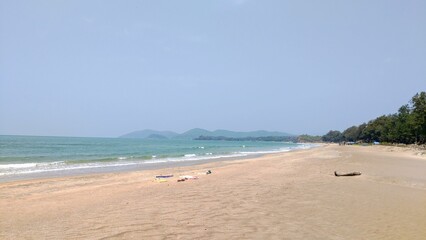 Serene beach with distant mountains under a clear sky.