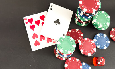 Poker cards and gambling chips on dark background
