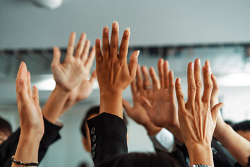 Many happy business people raise hands together with joy and success. Company employee celebrate...