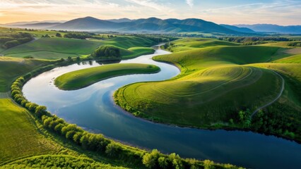 Obraz premium Breathtaking aerial view of rolling green hills and a winding river at sunset, perfect for nature, travel, or outdoor adventure themes