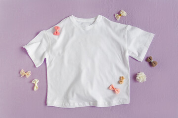 Blank white T-shirt  with hair accessories. Fashion mockup on the purple background. Flat lay, top view