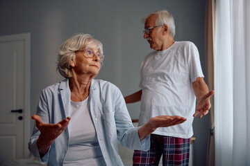 Senior woman having an argument with her husband in bedroom.
