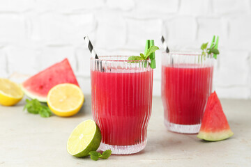 Delicious watermelon drink in glasses and fresh fruits on light table