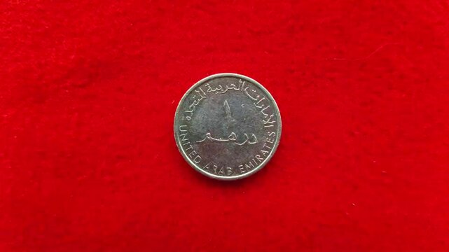 One United Arab Emirates dirham (AED) round nickel metal coin symbol was isolated. Extreme closeup macro top view. UAE government, economy, trade, recession, inflation, savings and forex concept.