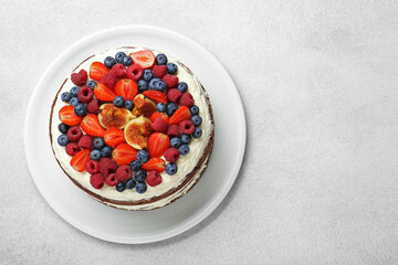 Delicious chocolate sponge cake with berries on light table, top view. Space for text