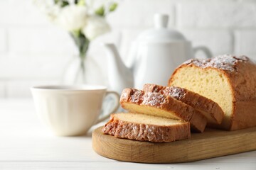 Freshly baked sponge cake on white wooden table, closeup. Space for text