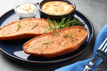Halves of tasty baked sweet potato served on grey table, closeup