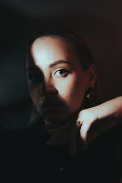 Mysterious woman in dramatic lighting with light and shadow contrast.