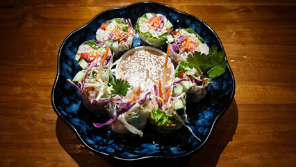Colorful Shrimp Vietnamese Fresh Spring Rolls with Hoisin Sauce Served in a Blue Plate on Wooden Table